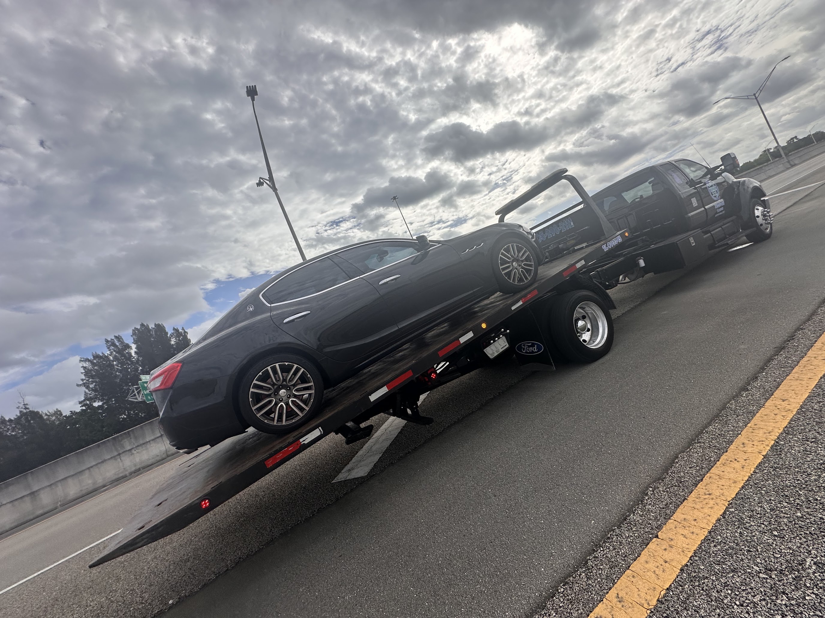 Rapid Towing 305 flatbed towing luxury sedan